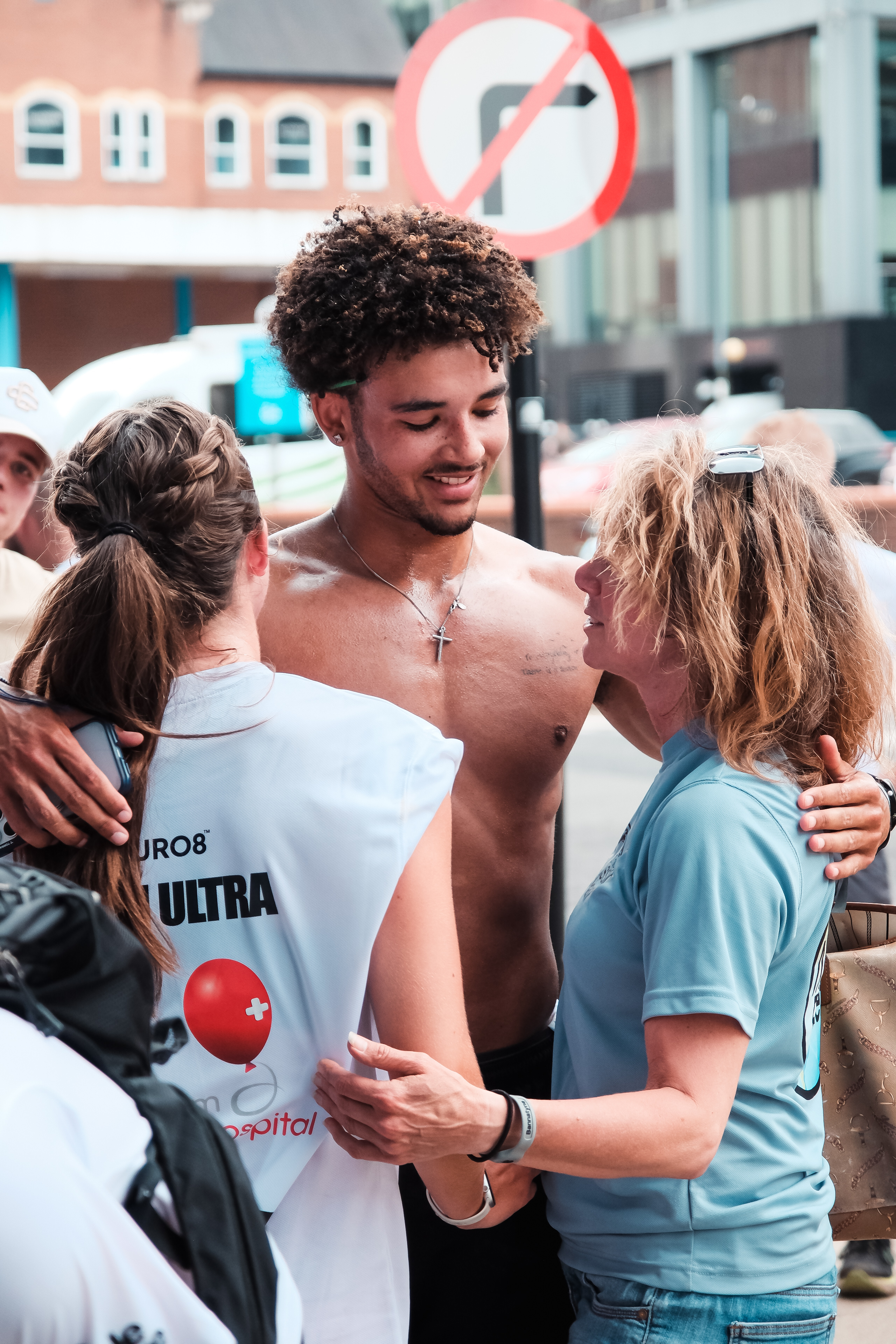 A runner embraced by family at the finish